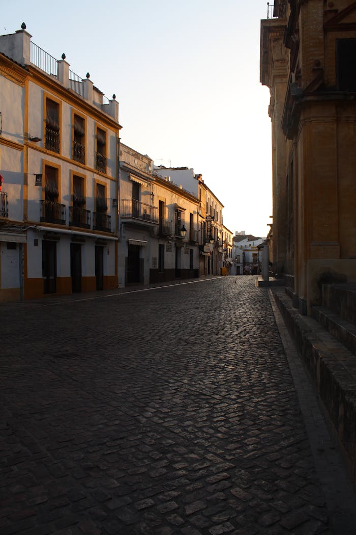 A peaceful street in Córdoba, Spain, captured at sunset showcasing traditional Spanish architecture.