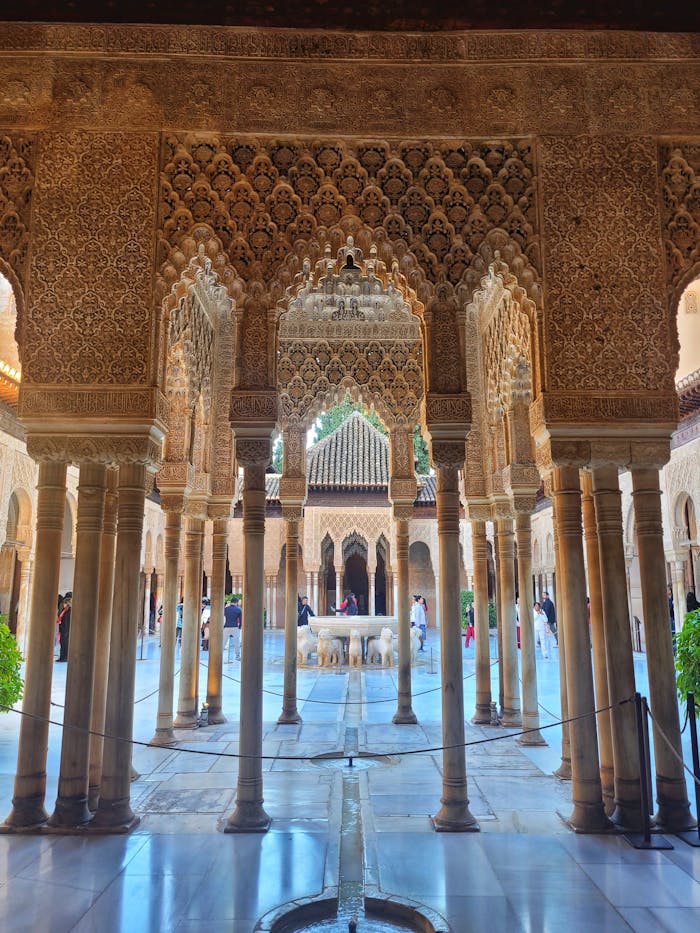 Intricate arches and columns of Alhambra's Moorish architecture captured in daylight.